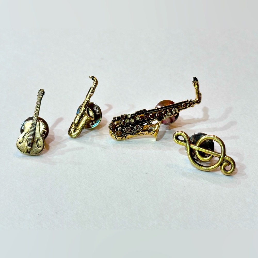 Assortment of musical instrument pins in antique brass color.
